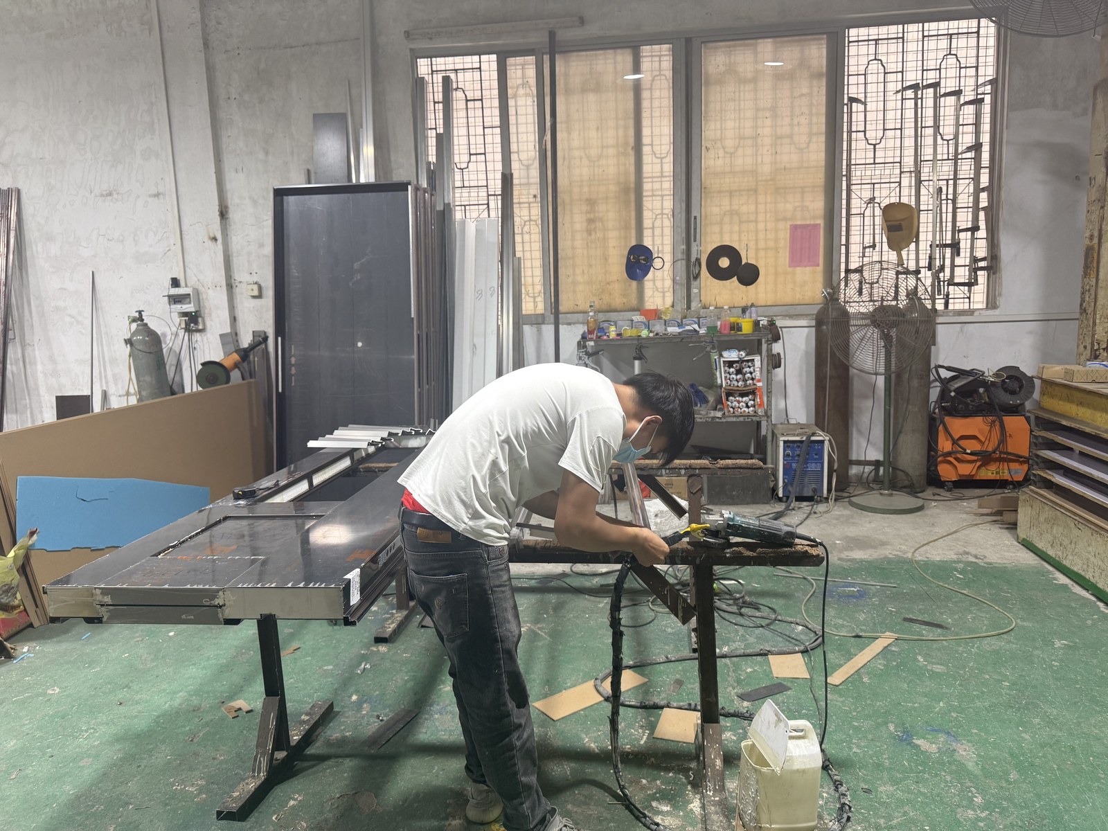 Frame and panel assembly bench with a door being fitted